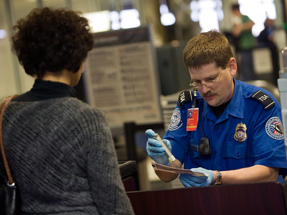 A TSA officer screens an airline passenger in Terminal C at Dallas/Fort Worth International Airport on Sunday. (Getty Images)