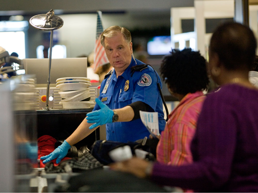 A TSA officer screens airline passengers at the Dallas/Fort Worth International Airport on Sunday. Preflight screenings were stepped up after a man was accused of trying to blow up a Northwest Airlines flight Friday. (Getty Images)