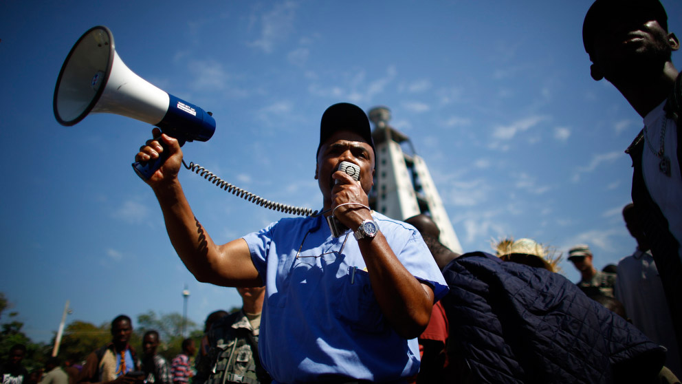 Dr. Henri Ford uses a bullhorn to spread the word about a U.S. medical clinic outside the presidential palace in Port-au-Prince. Ford, who grew up in Haiti's capital, says the city is now nearly unrecognizable to him. (NPR)