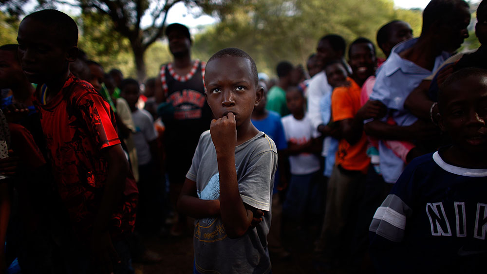 Men, women and children line up to receive water and food rations distributed by U.S. Army soldiers from the 82nd Airborne Division at a golf club on the hills above Haiti's capital, Port-au-Prince. (NPR)