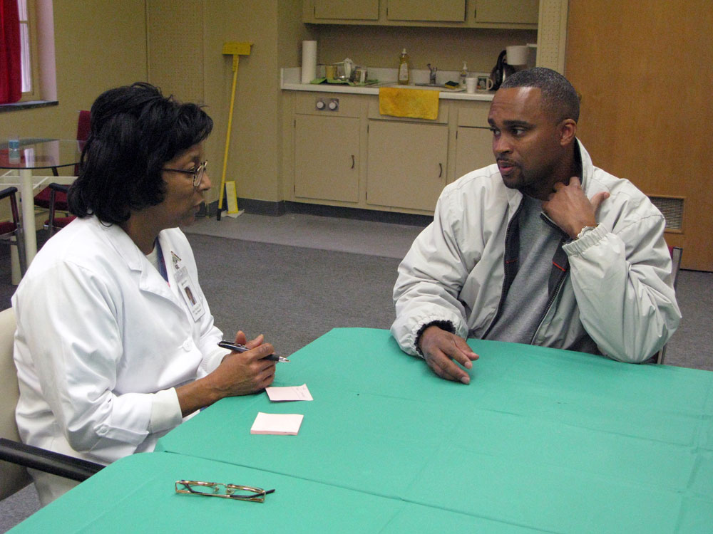 Patient Lee Hardy, who has been uninsured since Hurricane Katrina, speaks with nurse practitioner Mary Mackie at the New Orleans Faith Health Alliance. (NPR)