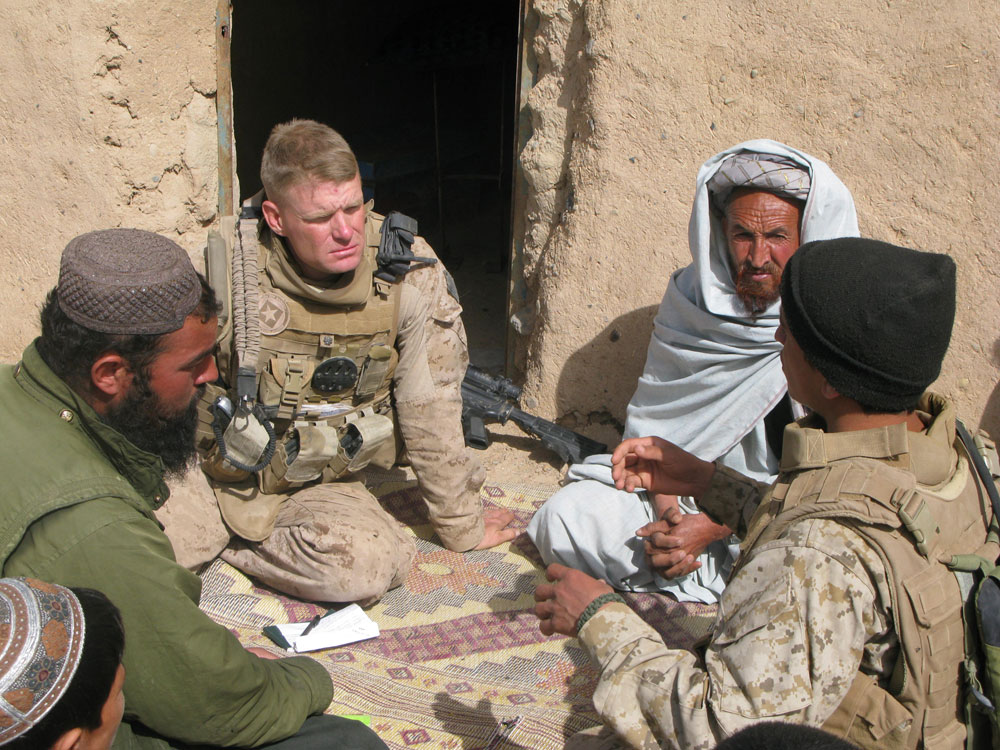 Marine Lt. Col. Brian Christmas listens as an interpreter translates the concerns of Marjah residents about opening a school. Local people fear the Taliban who have remained in the area, hidden among the population. Some residents have received &quot;night letters&quot; — notes from Taliban fighters threatening them with death if they deal with NATO or Afghan government troops. (NPR)
