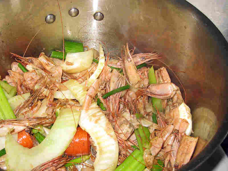 Shrimp shells and heads, carrots, celery and other ingredients in a stock pot