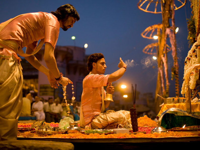 Priests in India perform the puja, a Hindu honor ceremony. Incense, flowers and candles are used to pay gratitude to Shiva and the River Ganges.