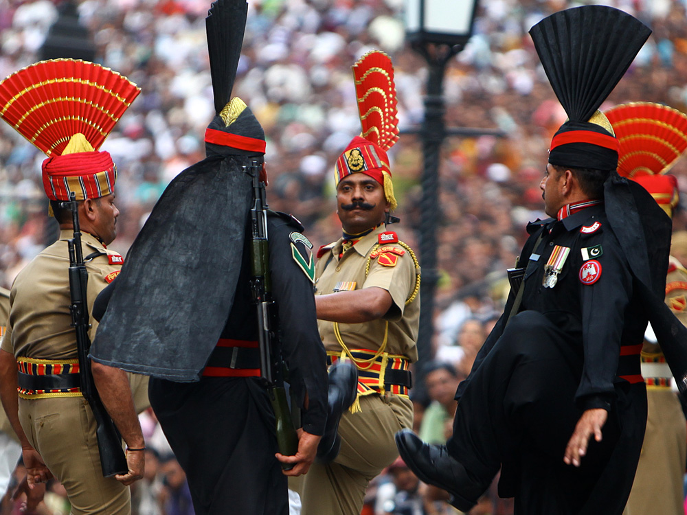 Pakistani Rangers (in black) goosestep at the Wagah border; India's border guards are in tan. The 30-minute ritual show of force and bluster happens every evening of the year. Hundreds of spectators come to watch the show -- from both sides of the border. (NPR)