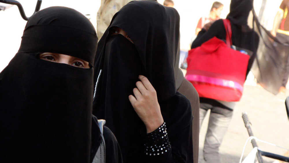 Elderly Muslim Arab Woman in Black Nikab and Abaya with a Handbag