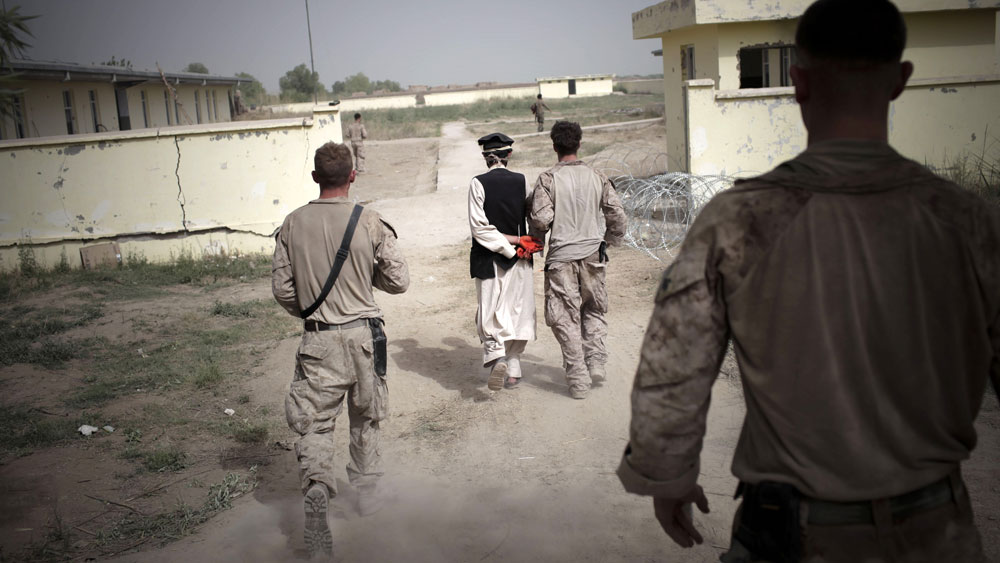 U.S. Marines lead an Afghan detainee toward their combat outpost for questioning in a Taliban stronghold area in Marjah, Helmand province, southern Afghanistan, April 1, 2010. The leak of more than 90,000 secret military intelligence reports on the war in Afghanistan paints a grim and often discouraging picture of the situation on the ground. (AFP/Getty Images)