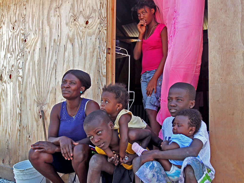 Wislyn Jean Charles (left) and her family were among the lucky ones to be assigned a transitional shelter at the Cite Soleil camp