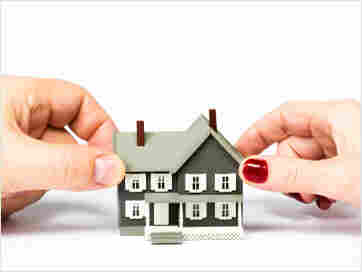 Hands touch model of house