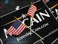 Two campaign posters for John McCain are covered by a pair of flags