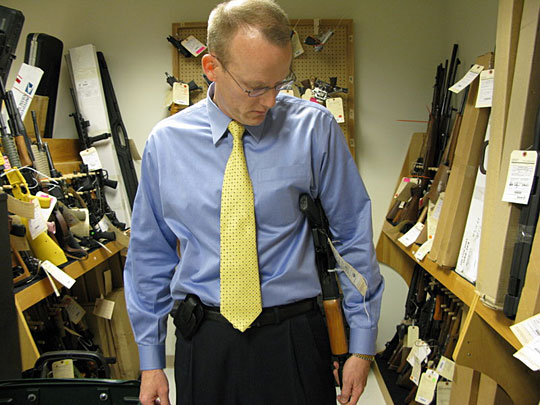 Special Agent Bill Newell shows how an AK-47 knockoff with a sawed-off stock can be hidden under a coat.