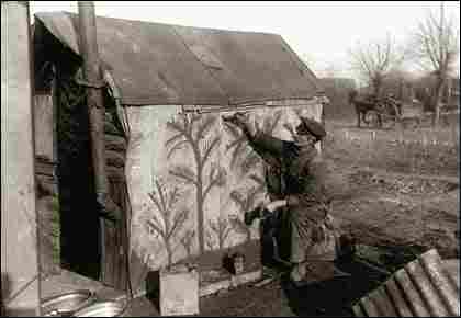 A soldier took the time to paint trees on canvas-like material covering the side of his hut.