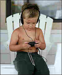 Young boy listening to a walkman with headphones.