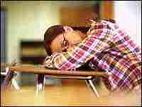 A teen asleep at her desk.