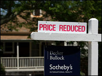 A realtor sign in San Anselmo, Calif., advertises a price reduction. Lower prices also translate into lower commissions for real estate agents. (Getty Images)