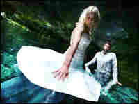 Woman stands in swamp in wedding dress.