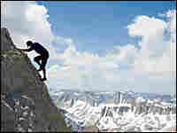 Mountain climber high on snowy peak.